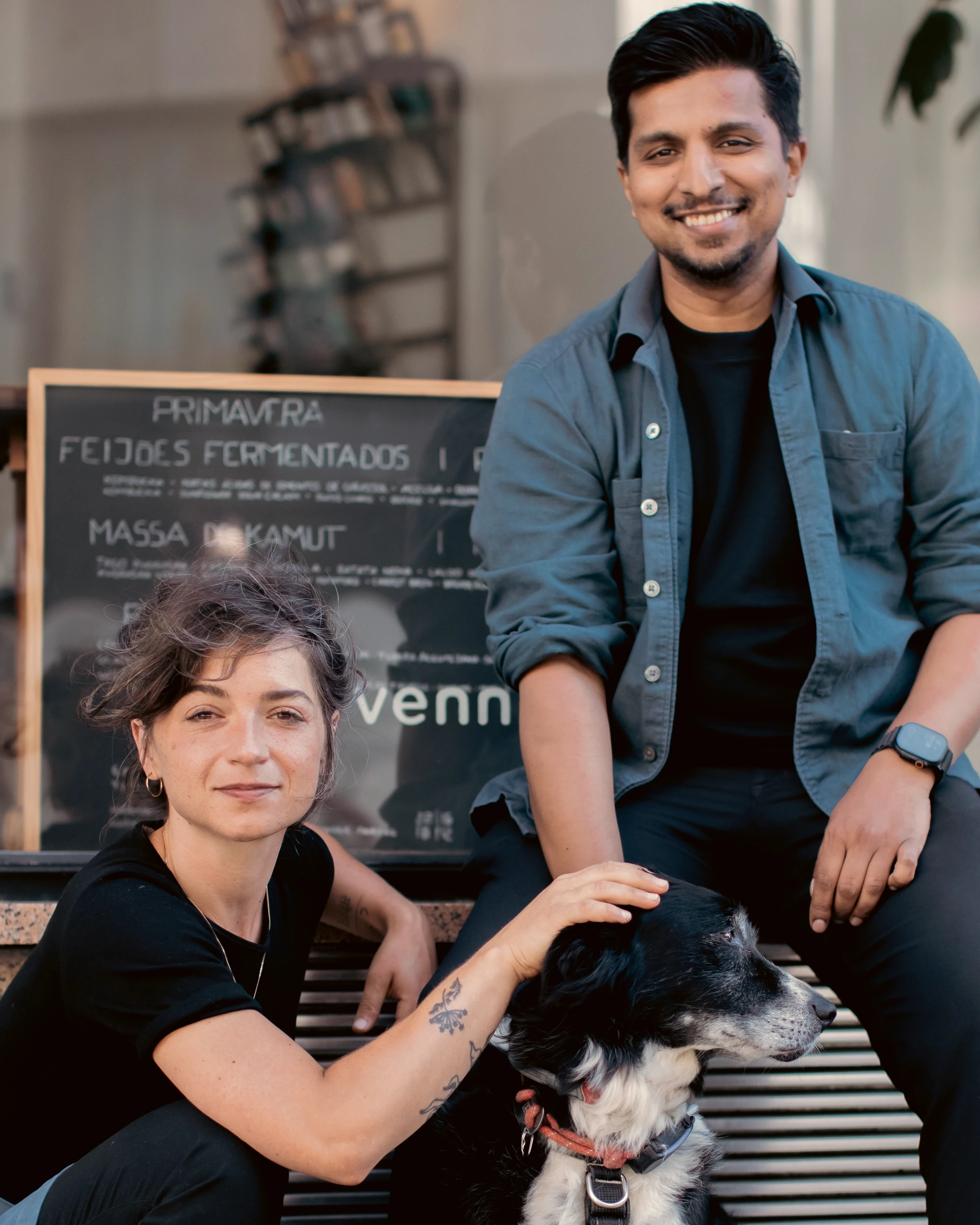 Monika Błoch e Snider Rodrigues com o cão do restaurante à porta do VENN Canteen, Porto