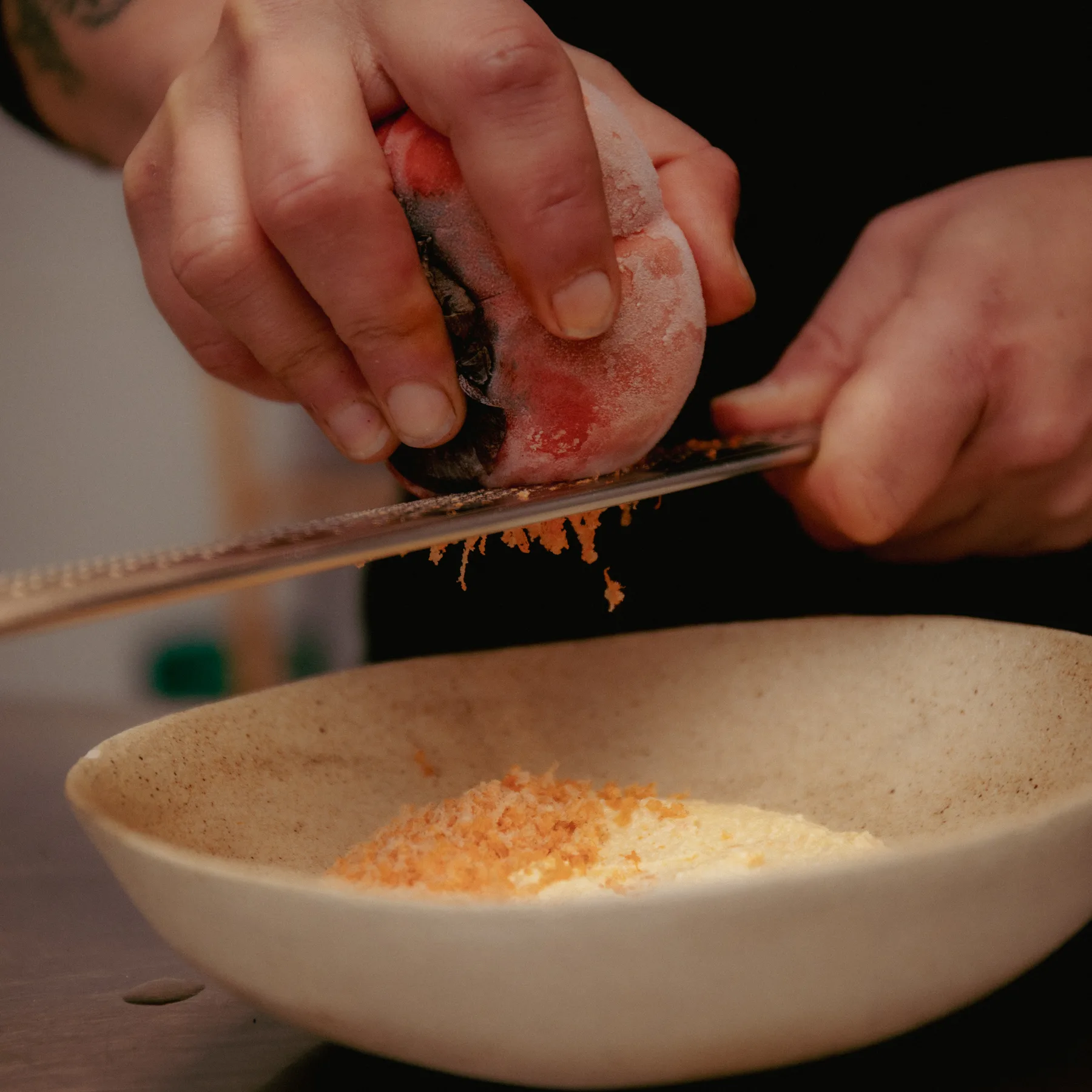 chef grating over a bowl, VENN kitchen