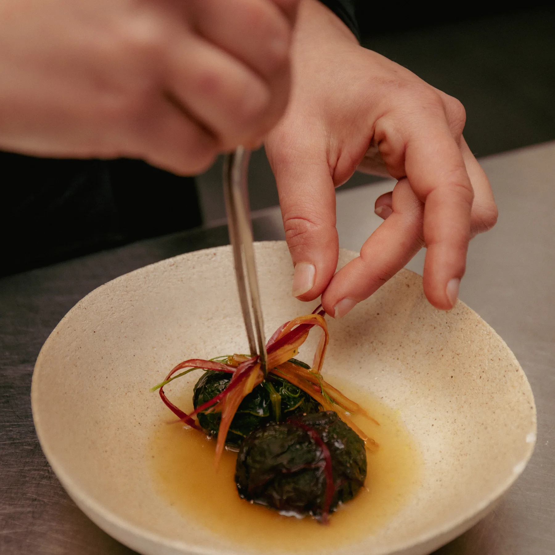 tweezers finishing a dish, VENN kitchen