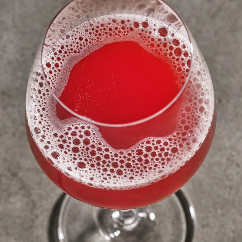 Fade to Black num copo de vinho, vermelho vivo sob uma espuma rosada