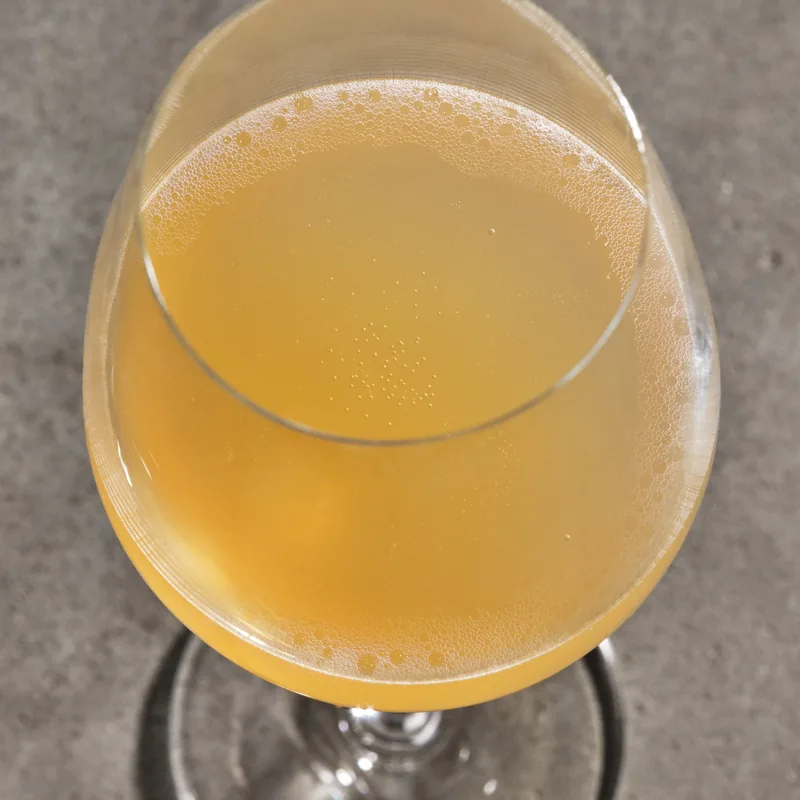 Passing Clouds num copo de vinho, dourado-claro, de bolha fina